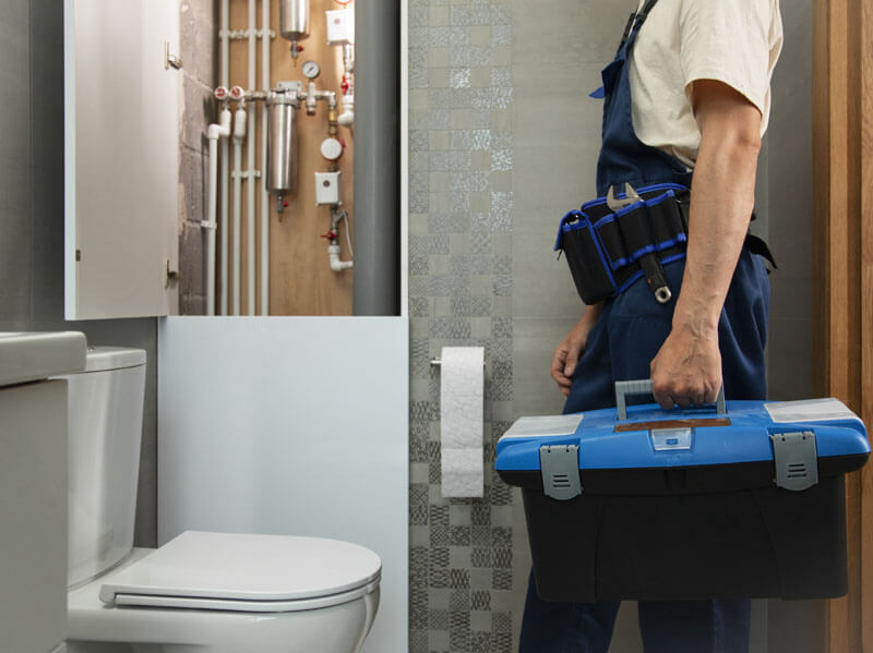 un plombier entrain de vérifier les toilettes